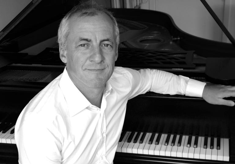 Aleksandar Madzar sitting by a piano