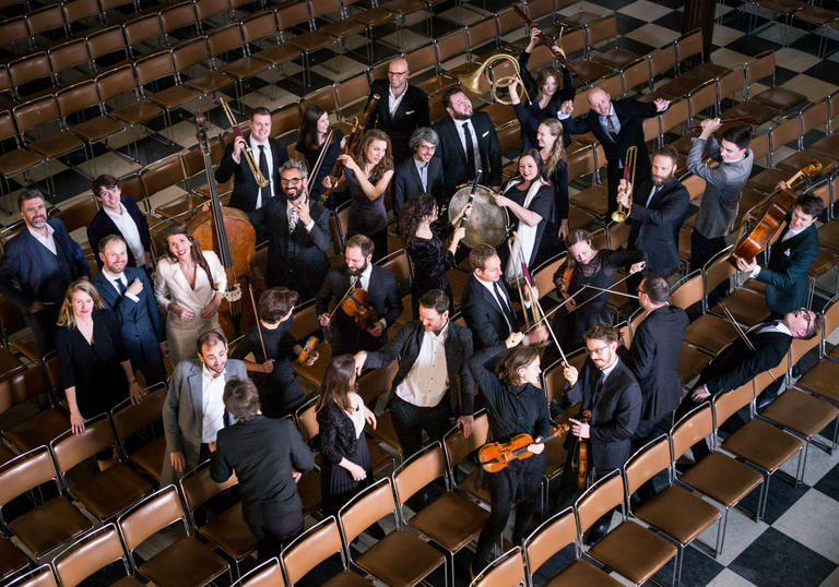 Solomon's Knot standing among chairs in an auditorium