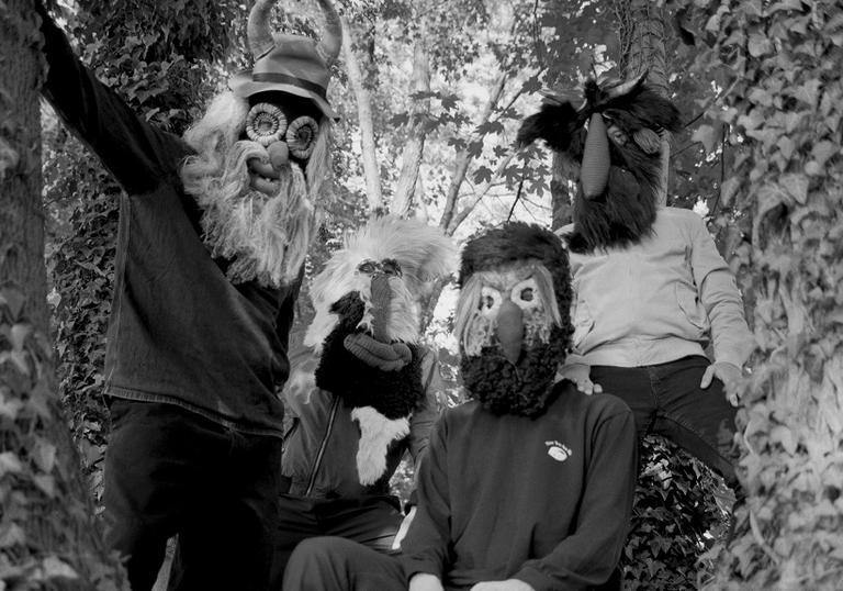 Pantha Du Prince and his collaborators in a tree wearing masks