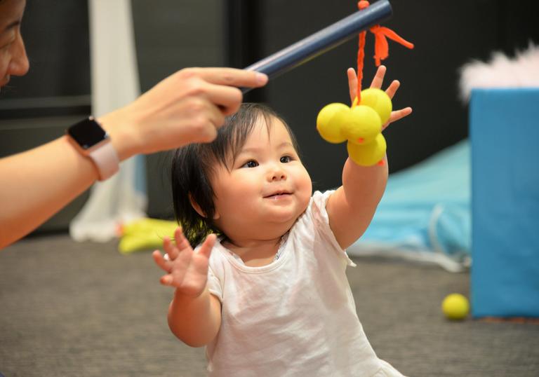 A toddler plays with their parent