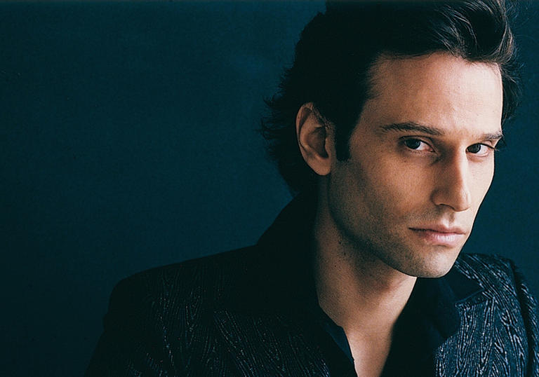 Pianist David Greilsammer in front of a dark background