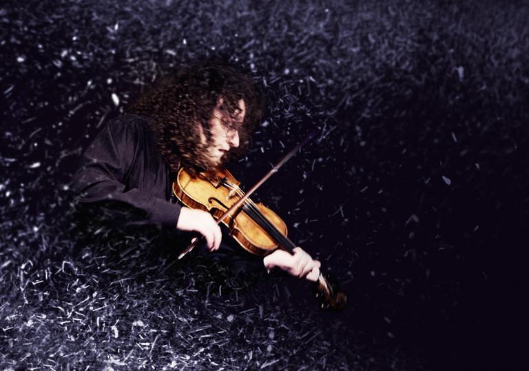 Martin Hayes playing the fiddle surrounded by a dust effect