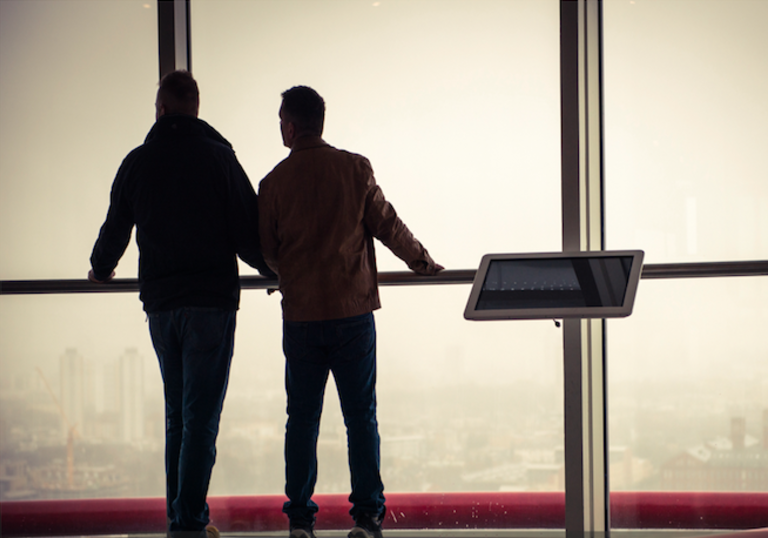 Two people looking out through glass