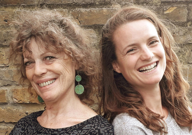 Workshop leaders Sally and Holly in front of a brick wall