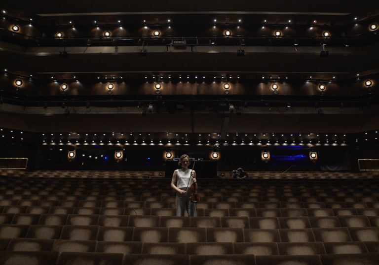 Woman playing violin in Barbican theatre