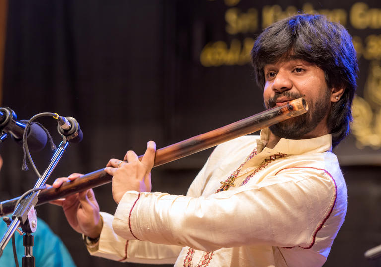 Jayanth playing a large wooden flute