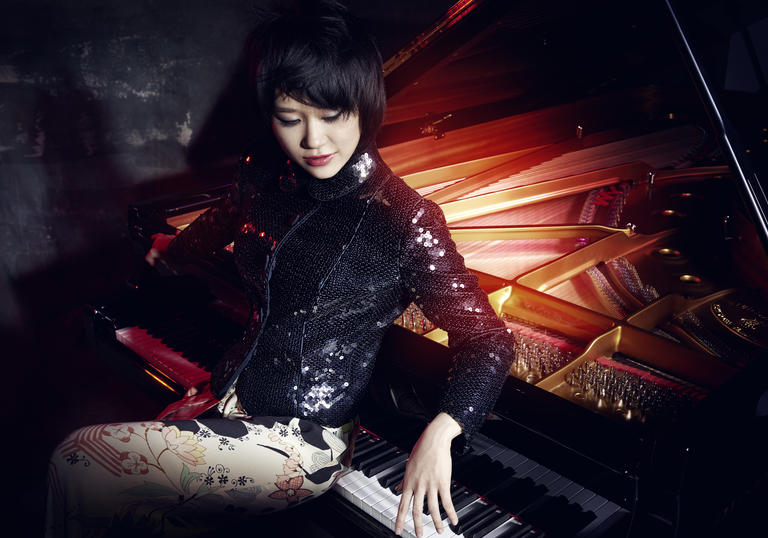 Yuja Wang sitting backwards at a piano