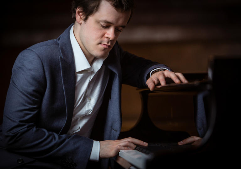 Benjamin Grosvenor sitting at a piano 2019