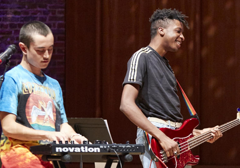 Young musicians perform on a synthesiser and a bass guitar