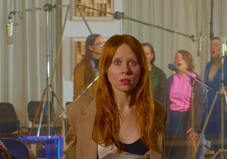 Holly Herndon in front of a choir recording