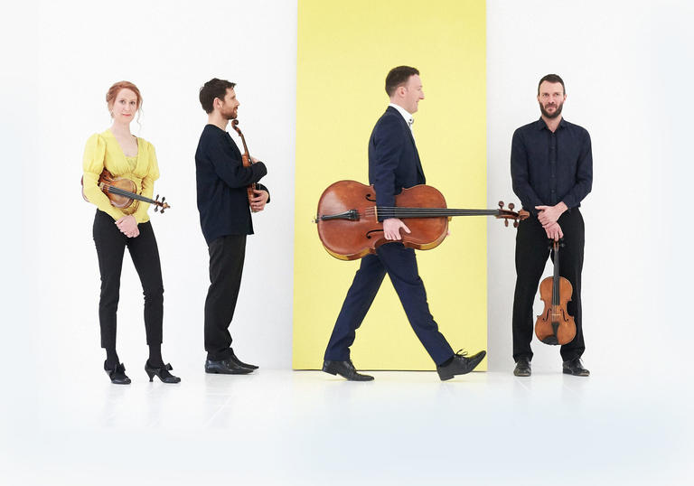 Heath String Quartet on white and yellow background holding instruments