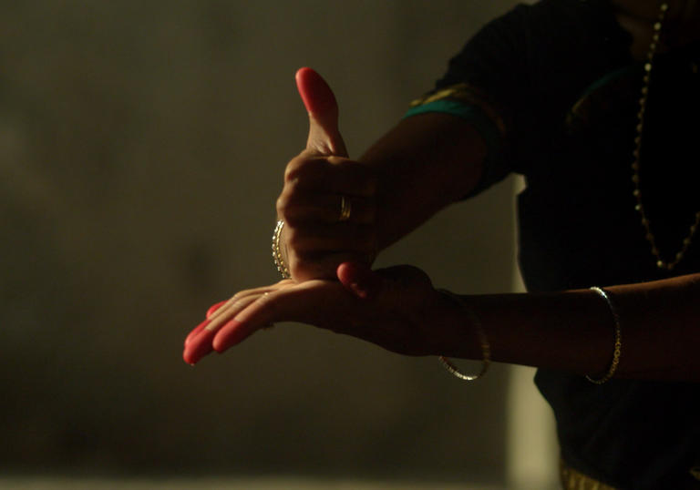 Dancing hands with henna and red nails