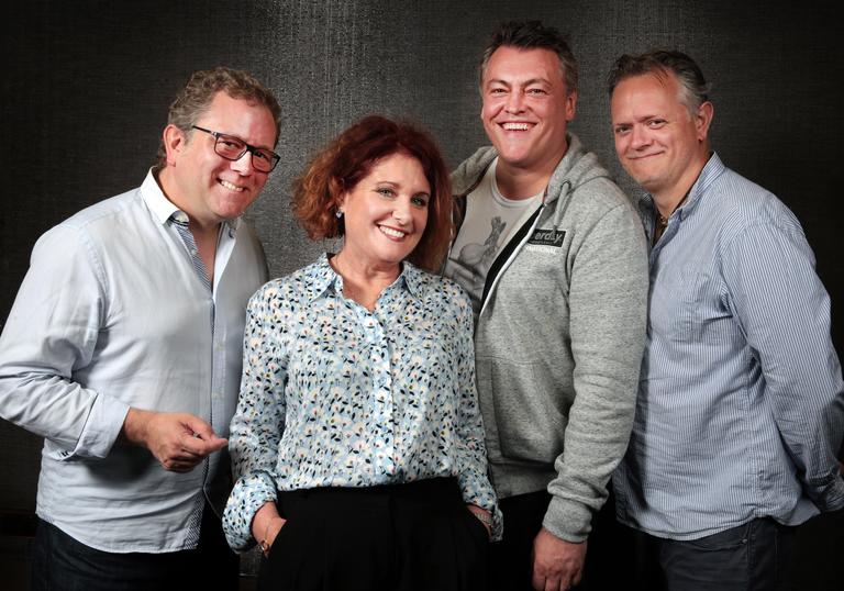 photo of three men and one woman smiling at the camera