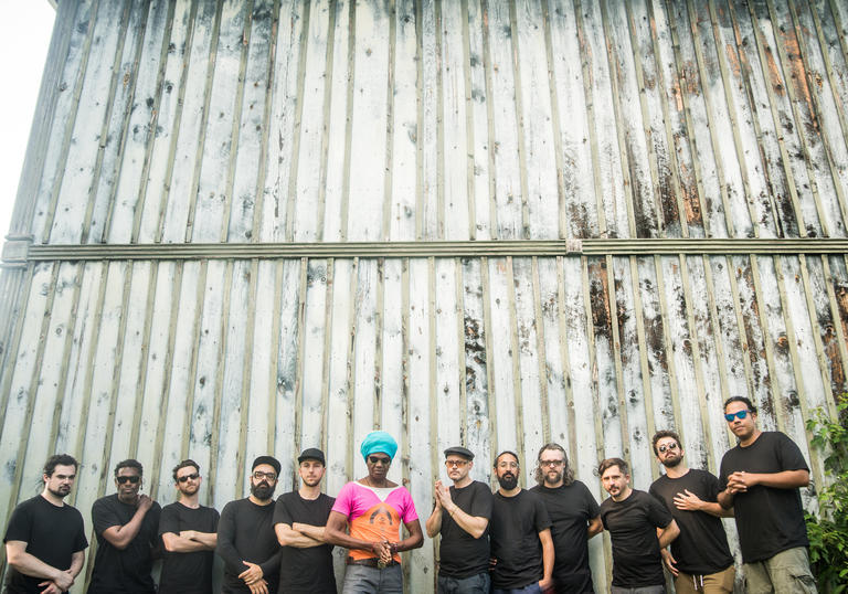 Antibalas in a line in front of a corrugated iron fence