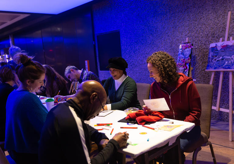 photo of a group of people working around a large table