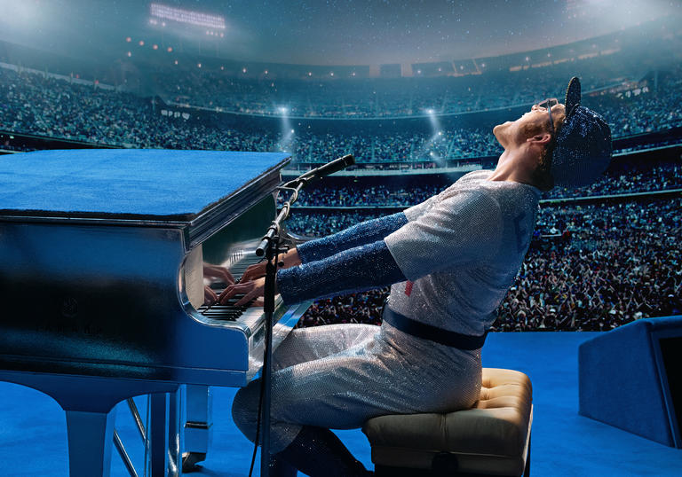 Taron Egerton as Elton John singing at a piano