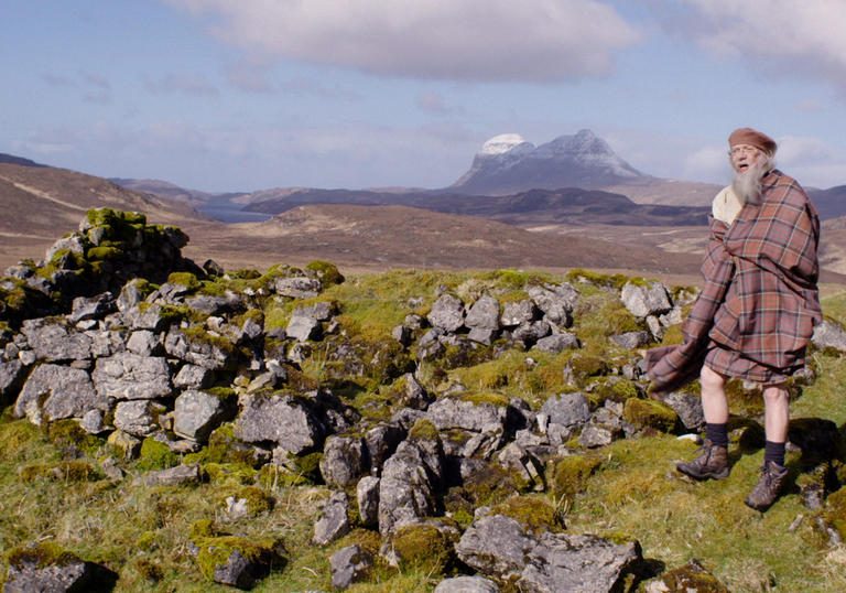 Man in kilt standing on a hill