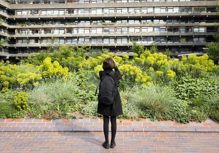 photo of someone looking at a lot of plants in front of the barbican centre
