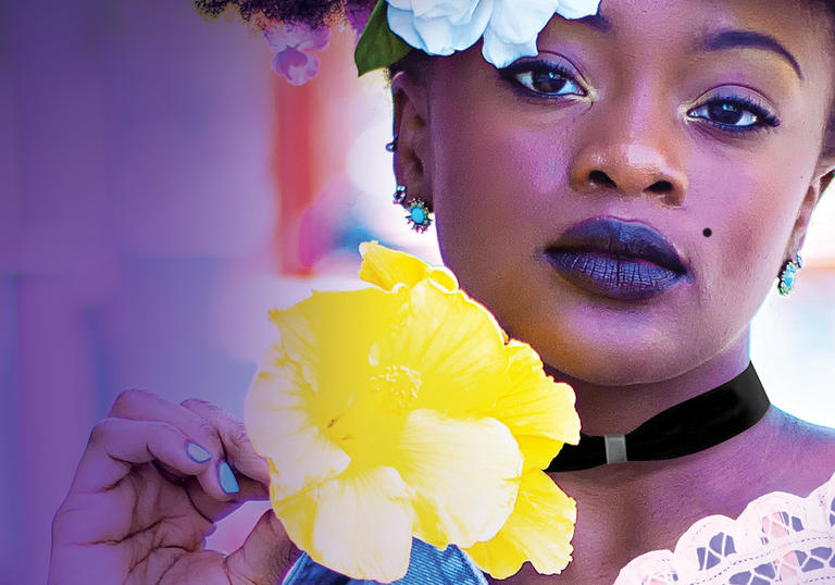 A young black woman in a modern outfit in style of the Restoration period, with colourful flowers and a fan