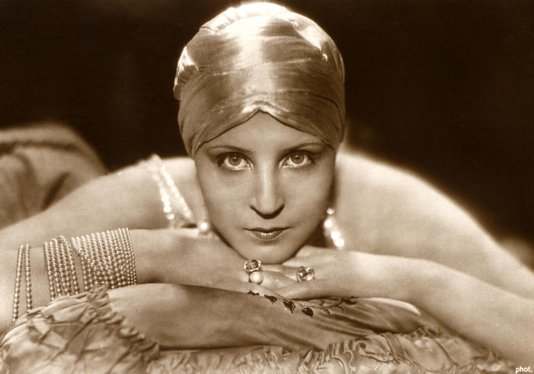 Brigitte Helm lying on a cushion with face resting upon her hands