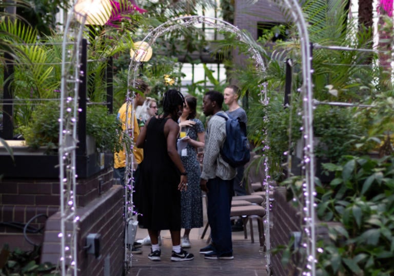 A group of people standing under an arch in conservatory