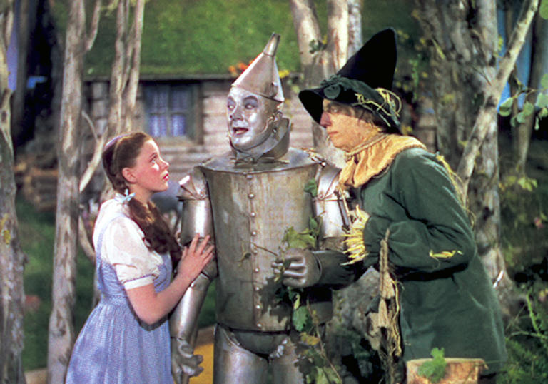 Dorothy, Tin Man and Scarecrow stand together in fear
