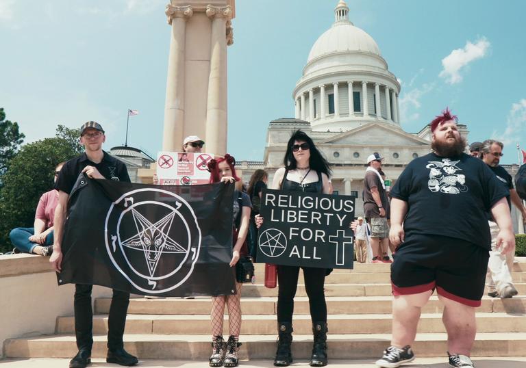 people standing in front of Capitol Hill holding signs encouraging religious liberty for all