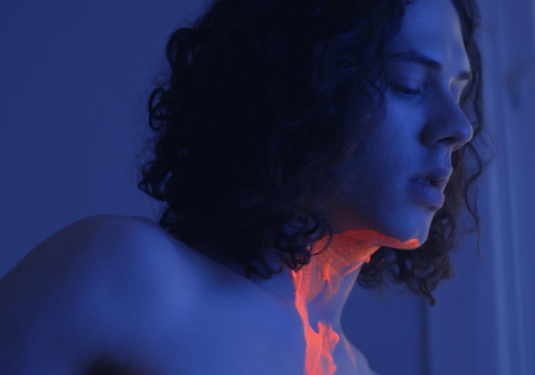 boy in dark room covered in neon paint