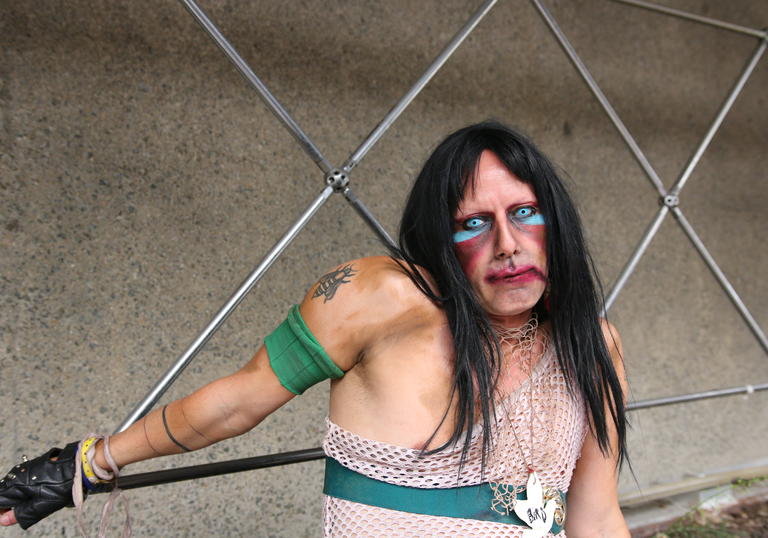 photo of CHRISTEENE posing against metal bars and a concrete background