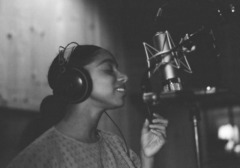 Lianne La Havas singing into a microphone