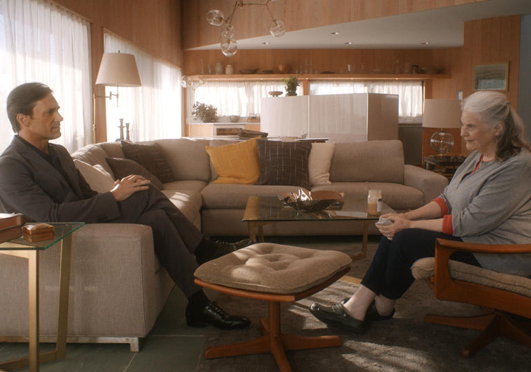 Jon Hamm and Louis Smith sitting opposite each other in a living room