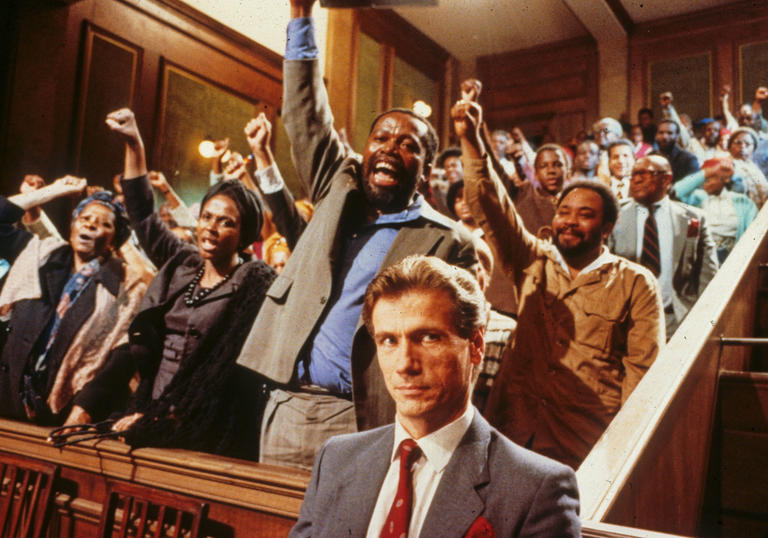 a group of black people standing up in court with their fists raised