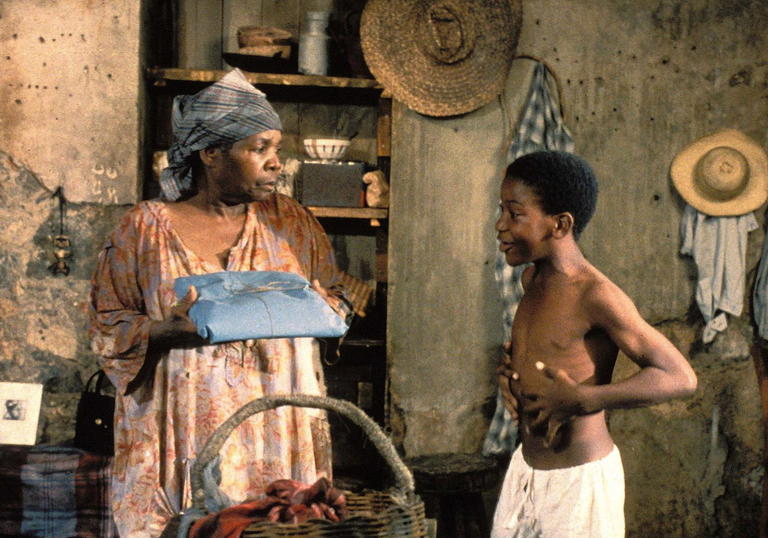 Jose and M'Man Tine stand facing each other in the kitchen