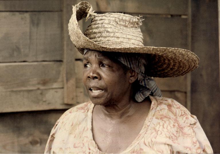 An image of Darling Légitimus in Sugar Cane Alley, wearing a wide-brim hat 