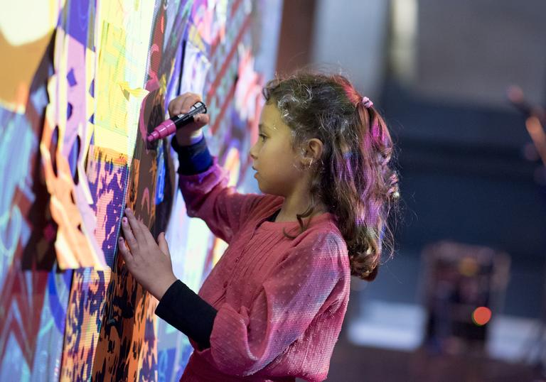 Girl drawing on a wall with projections