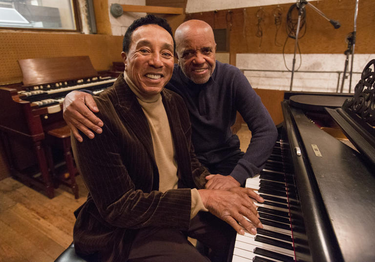 smokey robinson sitting at a piano