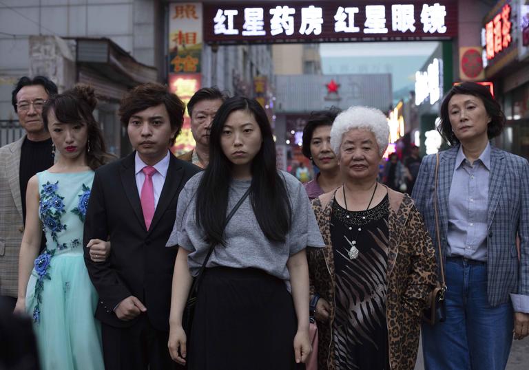 Awkwafina starring in The Farewell standing with her family around her