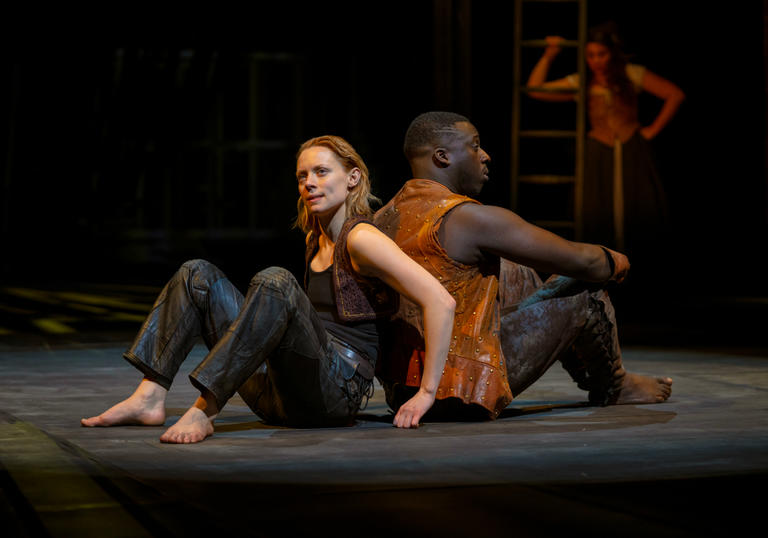 a woman and man sit back to back on the floor