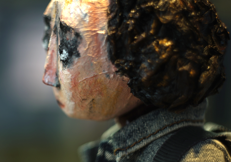 a papier mache woman looks forlornly in profile