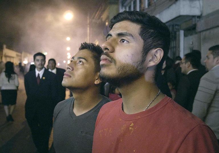 two men standing in a buy street looking upwards