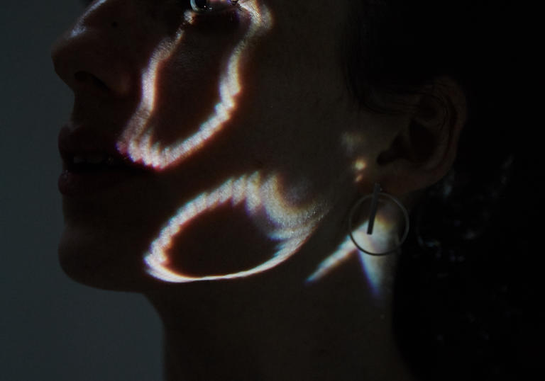 An image of a woman's face with a projection of the number zero on it