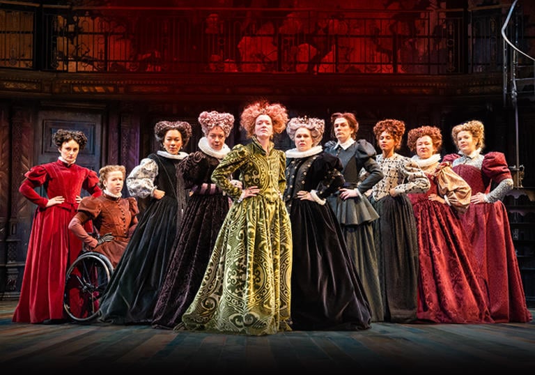 A collection of 10 female cast hold empowered poses on stage