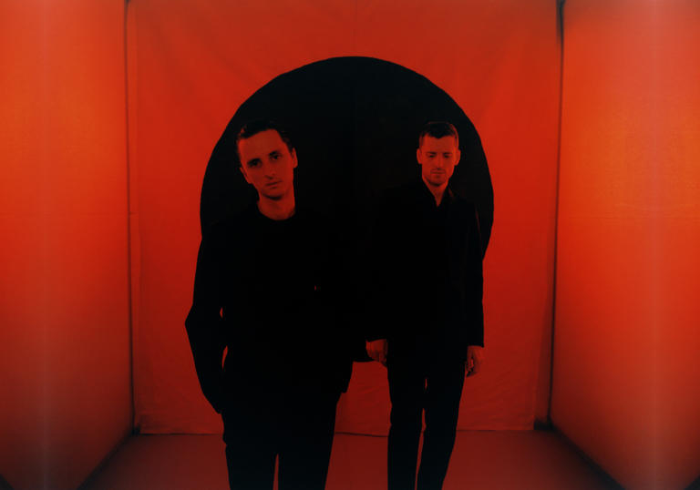These New Puritans standing in a red room