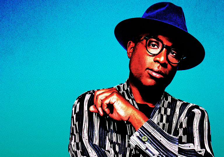 Alexis Ffrench wearing hat against a blue/green backdrop
