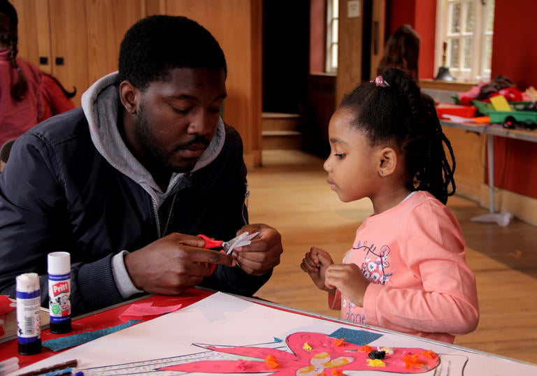 A father and daughter cut out shapes at the Imaginary Creatures Workshop