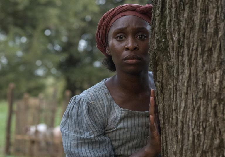 Cynthia Erivo as Harriet hiding behind a tree