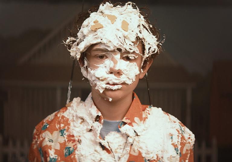 young Otis covered in cream from a cream pie