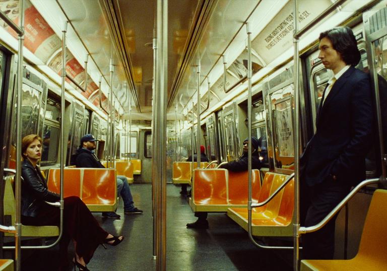 adam driver and scarlett johansson sit opposite each other on an empty subway train