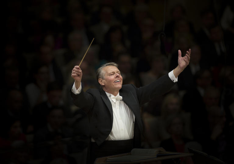 Mariss Jansons with raised arms conducting