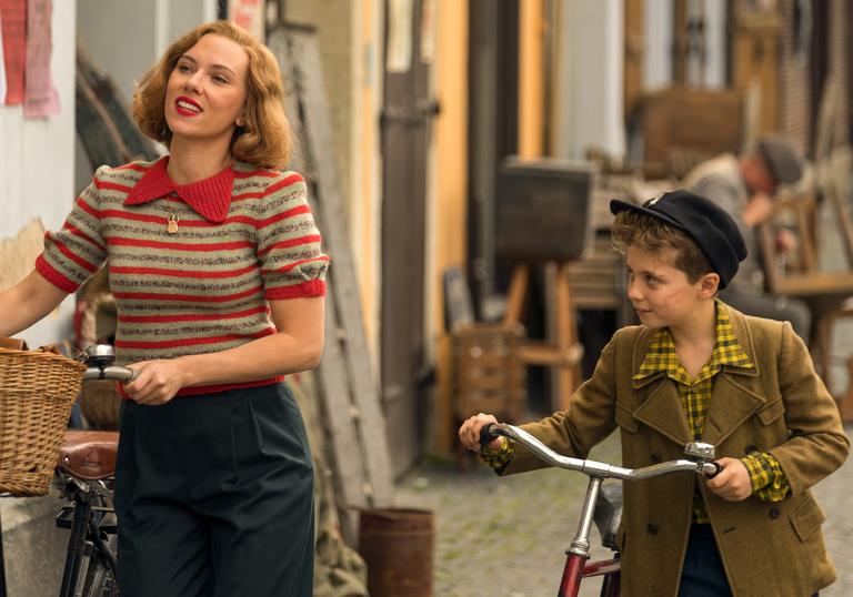 scarlett Johanssen and little Jojo walking down the street pushing bicycles